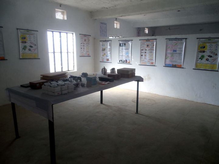 Physics laboratory with apparatus on a table and optics and magnetism charts on the walls